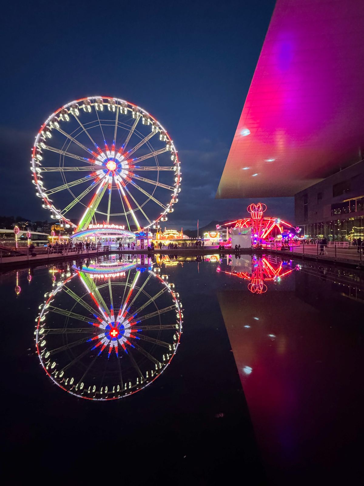 Riesenrad der Luzerner Määs spiegelt sich im Wasser beim KKL Luzern